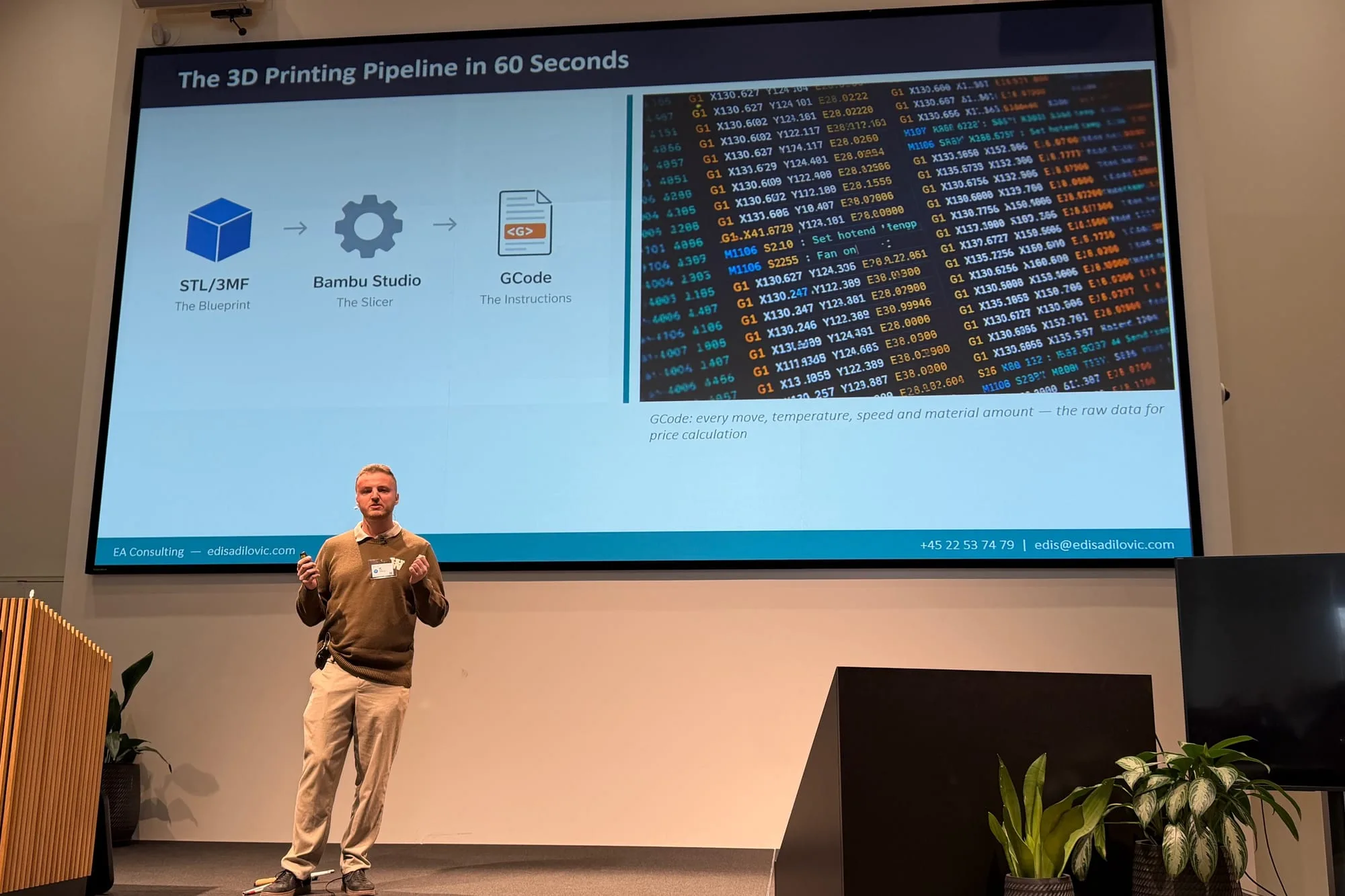 Edis stands on a stage at Microsoft, explaining with both hands. Behind him the screen shows the slide The 3D Printing Pipeline in 60 Seconds: from STL or 3MF file to slicer to G-code, with a block of G-code describing every move, temperature and amount of material.